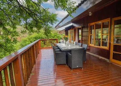 a wooden deck with a table and chairs on it at Highland Run Fly Fishing Estate by Dream Resorts in Lydenburg