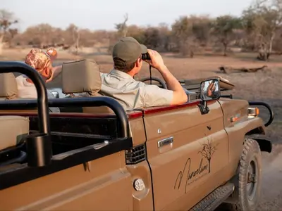 a man sitting in the back of a truck taking a picture at Maroelani Lodge- Greater Kruger Private Reserve in Hoedspruit