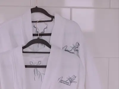 a white robe is hanging on a rack at Maroelani Lodge- Greater Kruger Private Reserve in Hoedspruit
