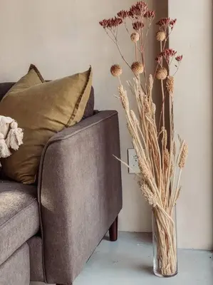 a vase with flowers sitting next to a couch at Shepherds Rest in Hoedspruit