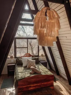 a bedroom with a bed and a large window at Shepherds Rest in Hoedspruit