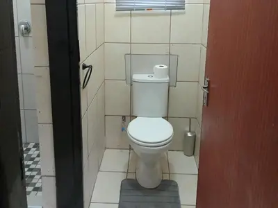 a bathroom with a white toilet in a stall at Lesedi Guesthouse Middleburg in Middelburg