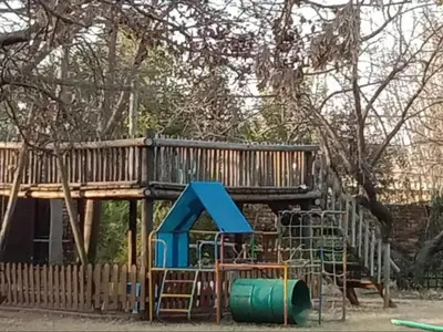 a playground with a wooden deck and a slide at Lesedi Guesthouse Middleburg in Middelburg