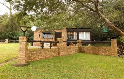 a brick fence in front of a house at The Outpost Dullstroom in Dullstroom