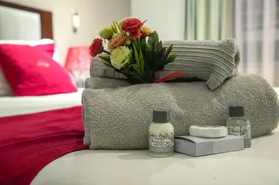 a bedroom with a couch with a flower arrangement on it at The Pillows Suite in Pretoria