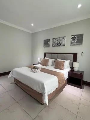 a bedroom with a bed and two pictures on the wall at The Pillows Suite in Pretoria