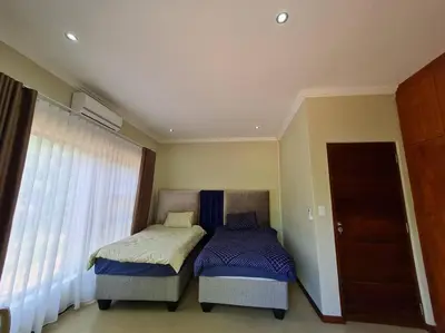 a bedroom with two beds and a window at No 16 Elements - 5 Bedroom Beauty in Moheme