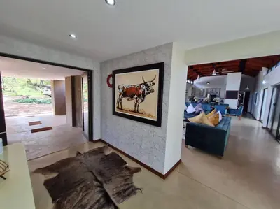 a living room with a painting of a cow on the wall at No 16 Elements - 5 Bedroom Beauty in Moheme