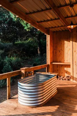 a wooden deck with a sauna with a wooden bench at Zwakala River Retreat in Haenertsburg