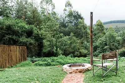 a chair and a fire pit in a yard at Zwakala River Retreat in Haenertsburg
