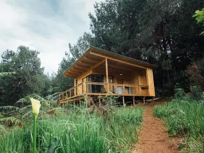 a wooden house in the middle of a field at Zwakala River Retreat in Haenertsburg