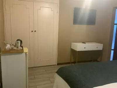 a bedroom with a bed and a white cabinet at Marina Views Guesthouse in Hartbeespoort