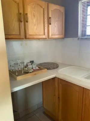 a kitchen with wooden cabinets and a counter top at Marina Views Guesthouse in Hartbeespoort