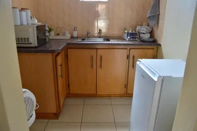 a small kitchen with a sink and a microwave at LEMEK Heights in Ga-Mothiba