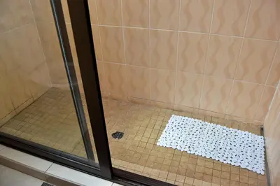 a shower with a glass door and a tile floor at LEMEK Heights in Ga-Mothiba