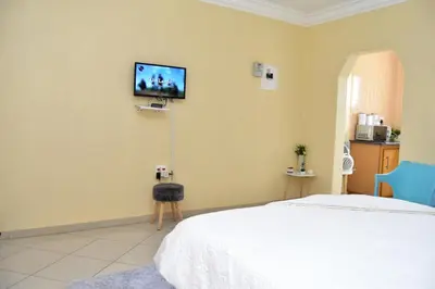 a bedroom with a bed and a tv on the wall at LEMEK Heights in Ga-Mothiba