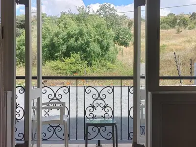 a balcony with two chairs and a view of a field at 131 on Herbert Baker Boutique Hotel in Pretoria