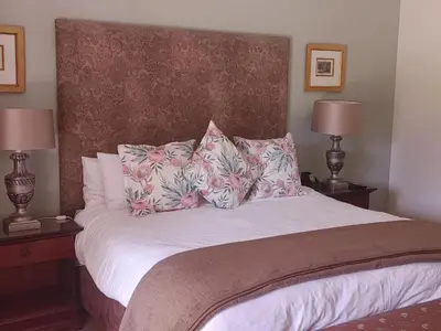 a bedroom with a bed with pillows and two lamps at 131 on Herbert Baker Boutique Hotel in Pretoria