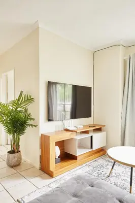 a living room with a tv on a wall at Beautiful Two Bedroom Appartment In Hatfield in Pretoria