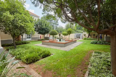 a garden with a fountain in the middle of a yard at Beautiful Two Bedroom Appartment In Hatfield in Pretoria