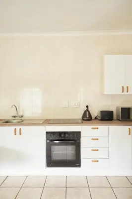 a kitchen with white cabinets and an oven at Beautiful Two Bedroom Appartment In Hatfield in Pretoria