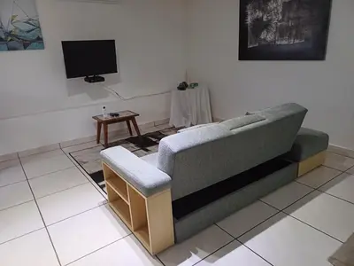 a living room with a couch and a tv at Green Scape Flatlet in Pretoria