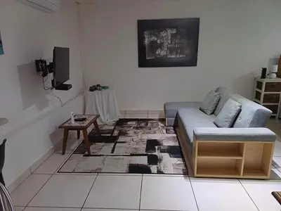 a living room with a couch and a table at Green Scape Flatlet in Pretoria