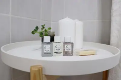 a white shelf with four products on it in a bathroom at Green Scape Flatlet in Pretoria