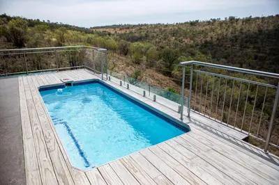 a swimming pool on top of a wooden deck at Elements Sunrise Bush Lodge in Bela-Bela