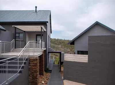a house with a staircase next to a building at Elements Sunrise Bush Lodge in Bela-Bela