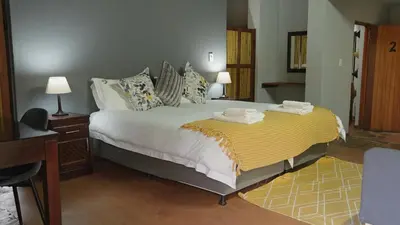 a bedroom with a large bed with towels on it at Livingstone Bush Lodge, Mabalingwe in Bela-Bela