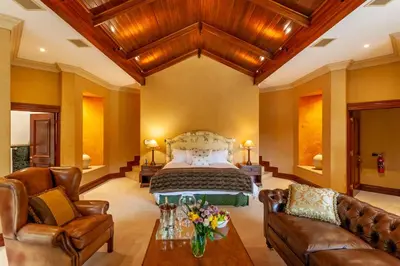 a bedroom with a bed and leather furniture at Lejwe La Metsi Private Reserve in Bela-Bela