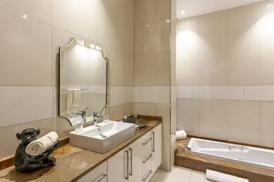 a bathroom with a sink and a mirror and a tub at Lejwe La Metsi Private Reserve in Bela-Bela