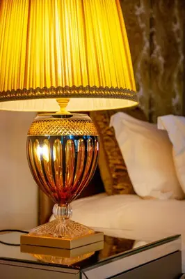 a yellow lamp sitting on a table next to a bed at Lejwe La Metsi Private Reserve in Bela-Bela