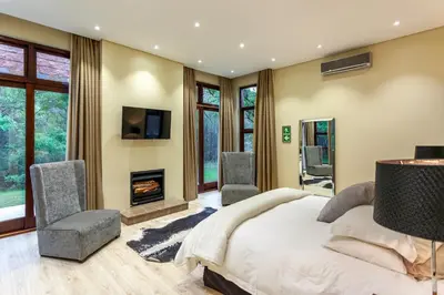 a bedroom with a large bed and a fireplace at Lejwe La Metsi Private Reserve in Bela-Bela