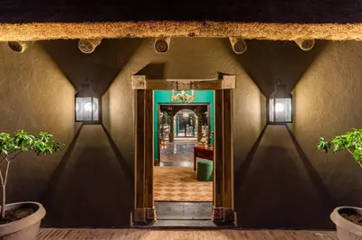 a hallway with a doorway into a house with lights at Ukuthula House in Hectorspruit