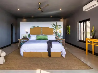 a bedroom with a large bed with green pillows at Ukuthula House in Hectorspruit