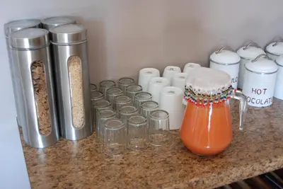 a counter with a bunch of containers of food at Journey's Inn Africa Guest Lodge in Kempton Park