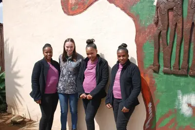 a group of girls standing in front of a wall at Journey's Inn Africa Guest Lodge in Kempton Park