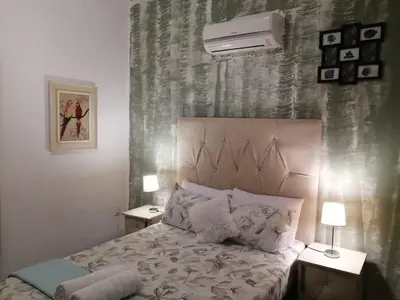 a bedroom with a bed with two night stands and two lamps at Palm View Guest House in Pretoria