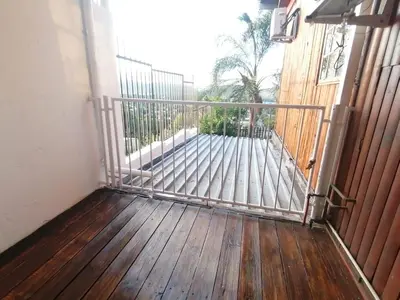 a gate on a porch with a wooden deck at Palm View Guest House in Pretoria