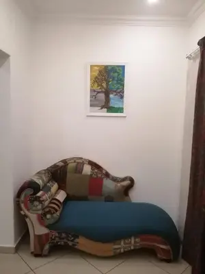 a couch in a room with a picture on the wall at Palm View Guest House in Pretoria