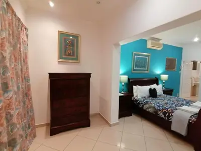 a bedroom with a bed and a blue wall at Palm View Guest House in Pretoria