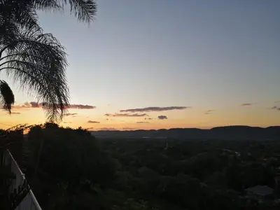 a sunset with a palm tree in the foreground at Palm View Guest House in Pretoria
