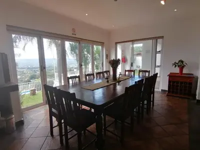 a dining room with a wooden table and chairs at Palm View Guest House in Pretoria