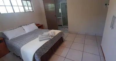 a bedroom with a bed with a towel on it at Nature Cottage in Marloth Park