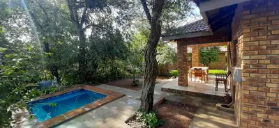 a swimming pool in the backyard of a house at Nature Cottage in Marloth Park