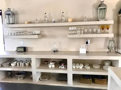 a shelf filled with lots of glasses and other items at Vetho Farmhouse Dullstroom in Dullstroom