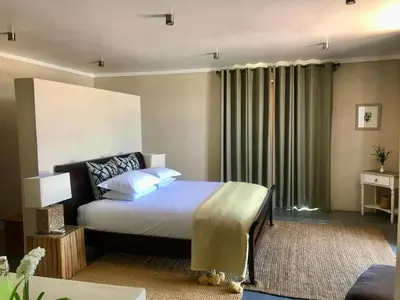 a bedroom with a bed and a large window at Vetho Farmhouse Dullstroom in Dullstroom