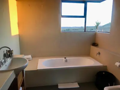 a bathroom with a large tub and a sink at Vetho Farmhouse Dullstroom in Dullstroom